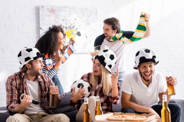 excited group of friends watching a game at home depicting freedom from disturbing people due to proper insulation