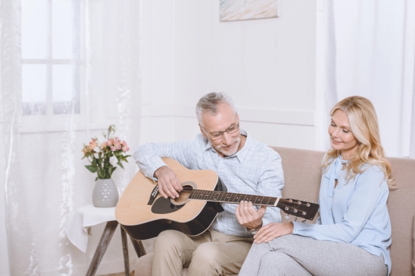 man playing guitar in the living room depicting absorption of sound waves