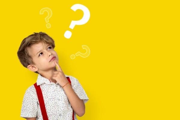 little boy looking at question marks depicting common questions about spray foam insulation