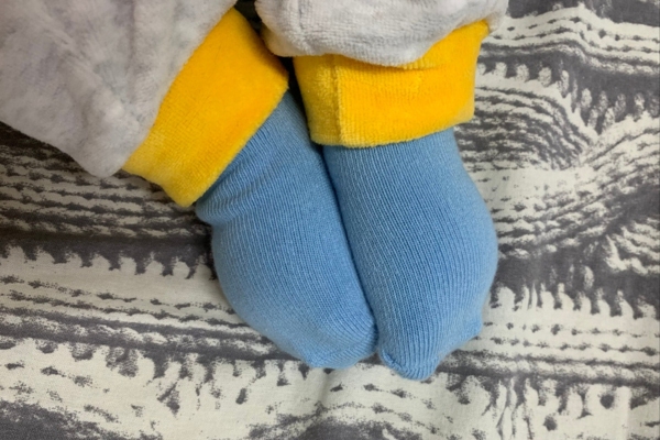 feet of a child wearing socks on top of rug depicting cold floors