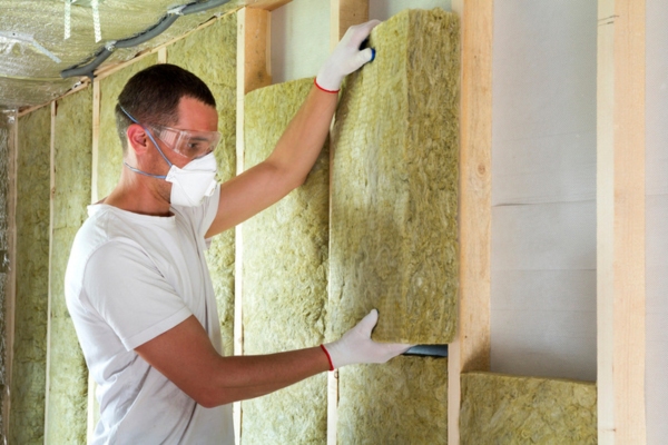 professional contractor installing mineral wool insulation on the wall