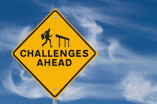 challenges ahead yellow sign against blue and white sky depicting challenges insulating tiny home