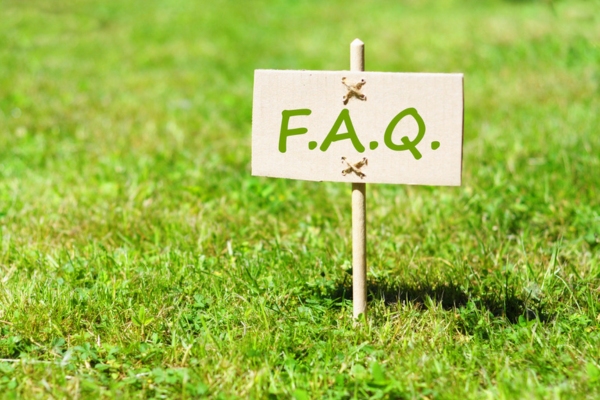 FAQ wood sign placed on ground with a stick