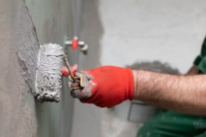 handyman applying insulating paint on the wall