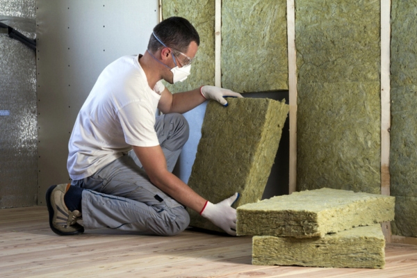 worker installing wall insulation depicting upgrade