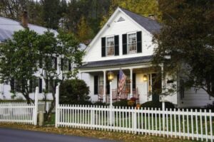 image of an Old House with white picket fence and USA flag